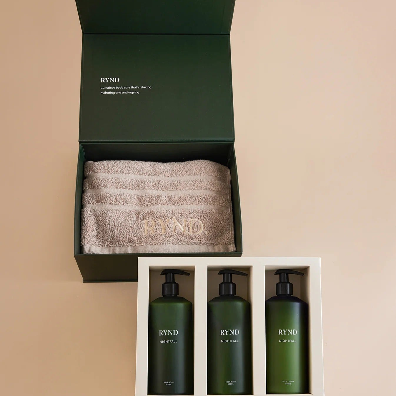 RYND bath and body set with three bottles and a towel in a box on a beige background