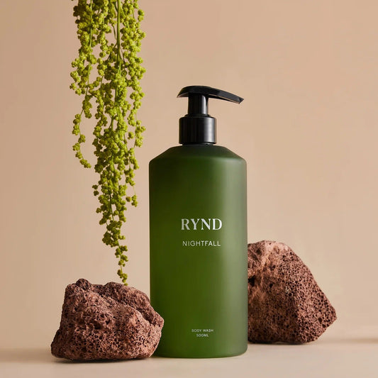 Green bottle labeled 'RYND Nightfall' with decorative elements on a beige background