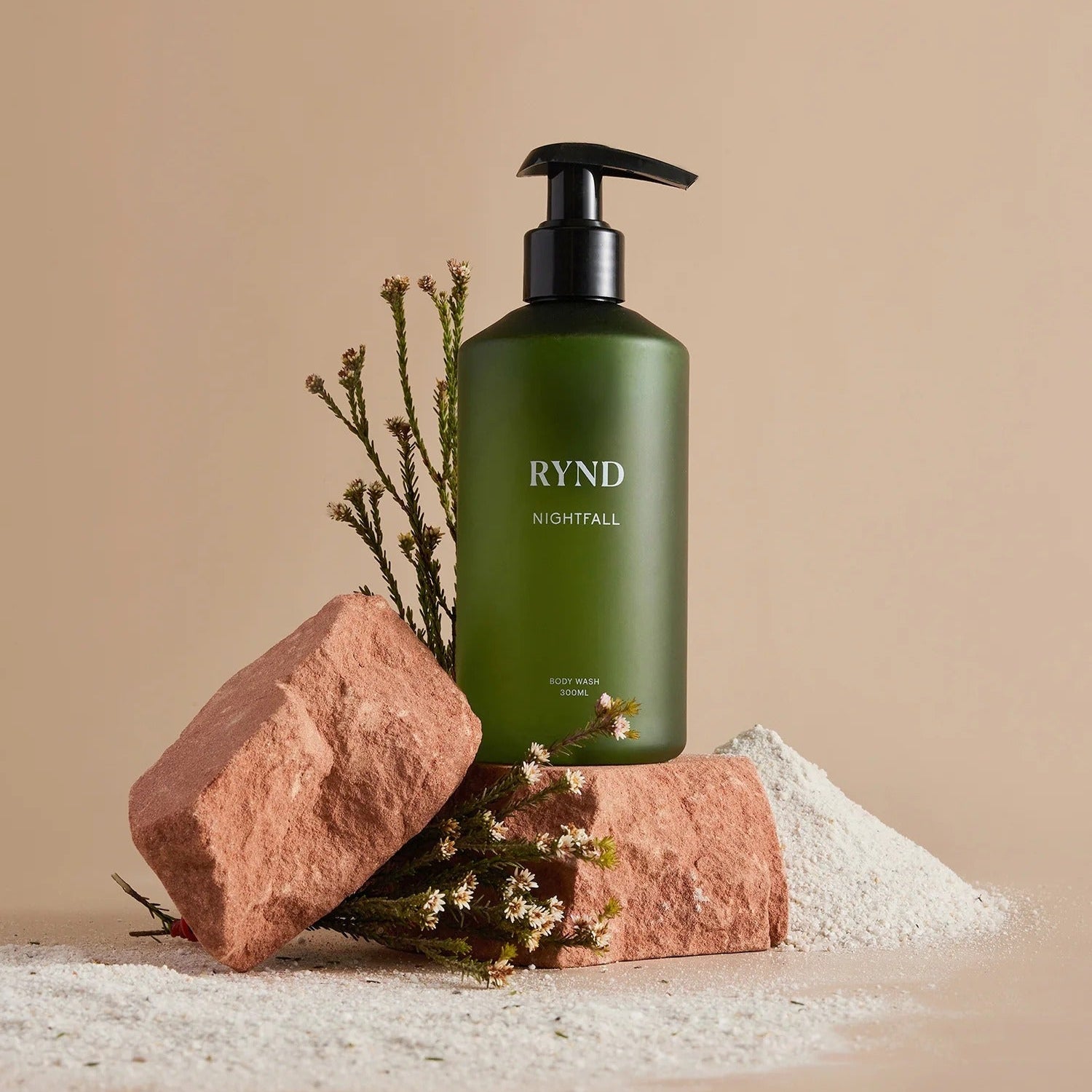 Green bottle labeled 'RYND' with decorative elements on a beige background