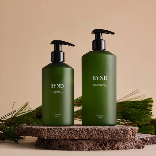 Two green bottles labeled 'RYND' on a beige background with pine branches.